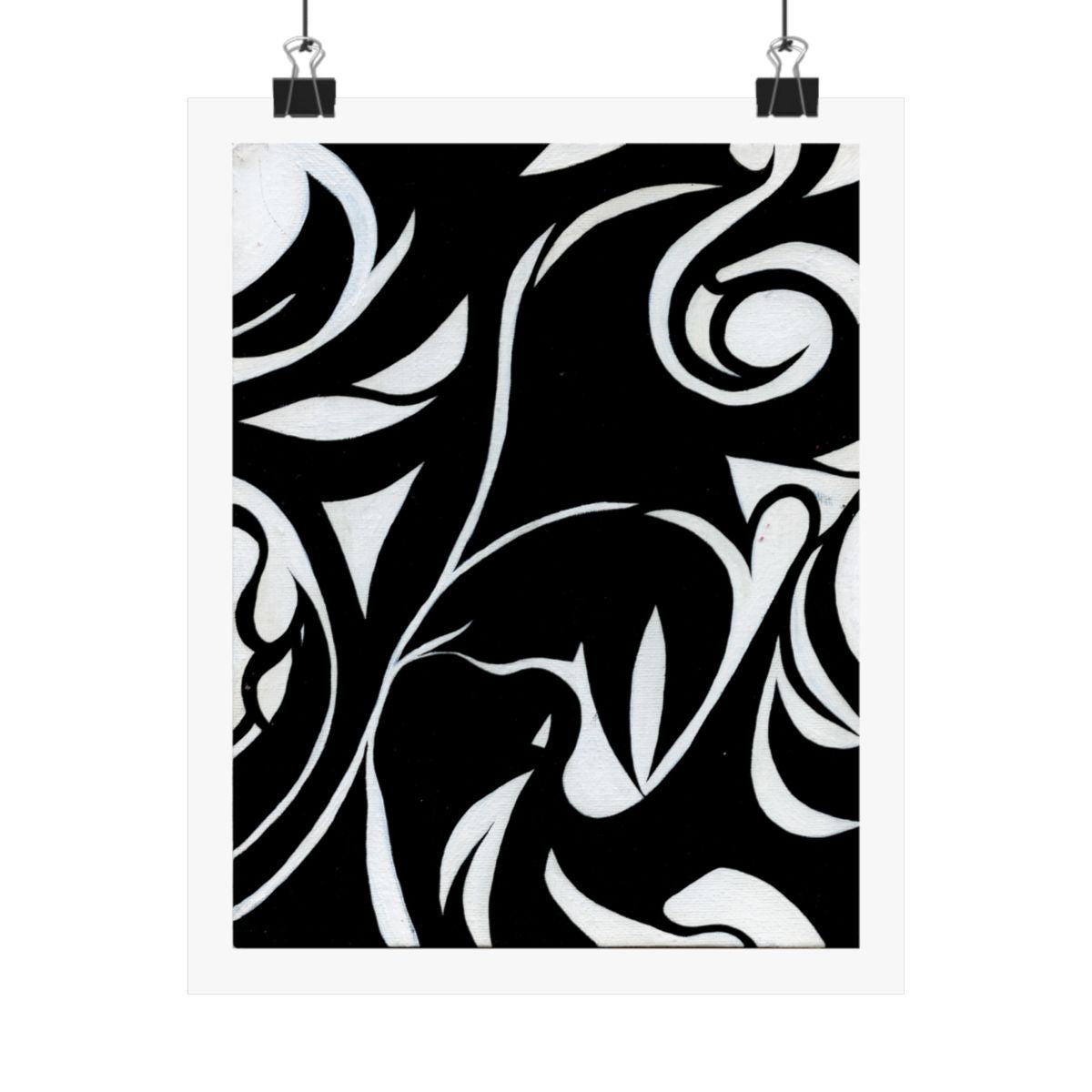 Print of an abstract painting in white on black, flowing leaf and vine forms, shown hanging from binder clips.